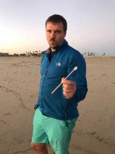 man_holding_up_plastic_straw_at_the_beach1